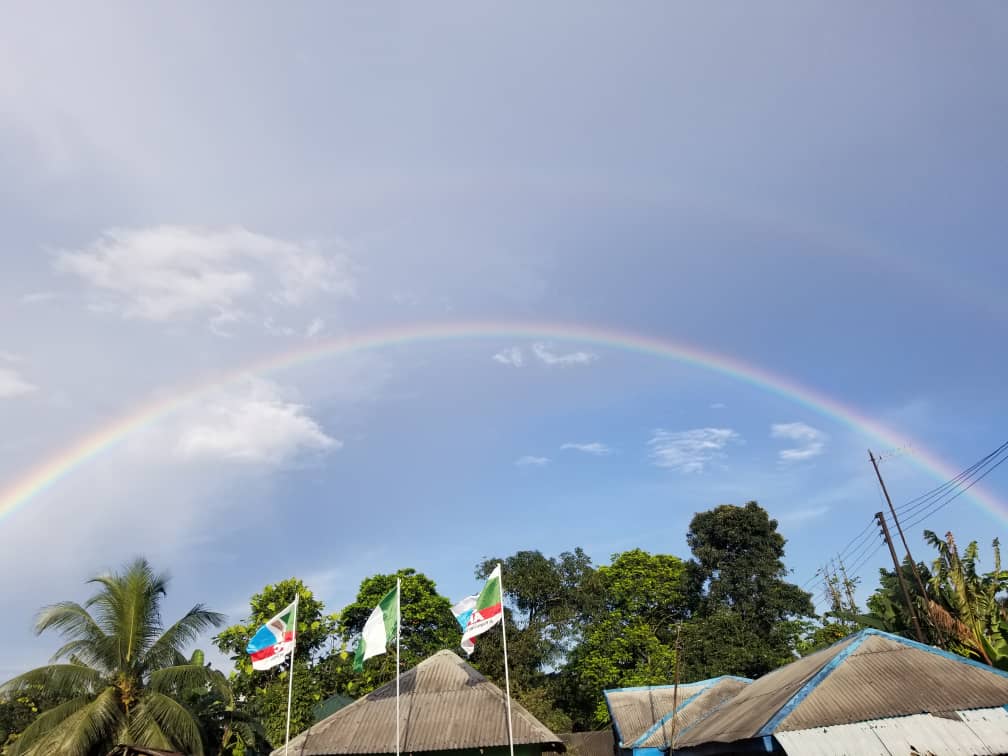 Rainbow across the blue sky with clouds