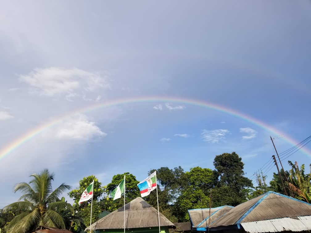 Rainbow across the blue sky with clouds