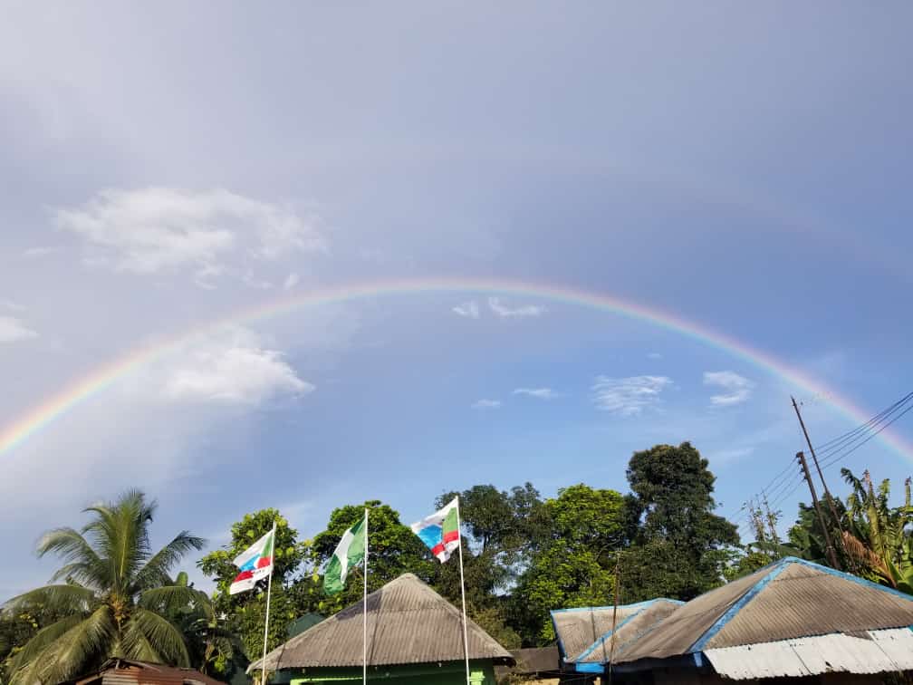 Rainbow across the blue sky with clouds