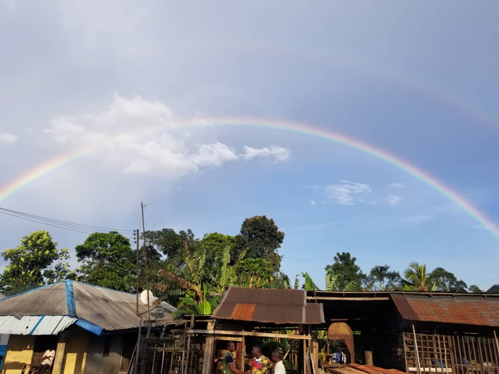 Rainbow across the blue sky with clouds