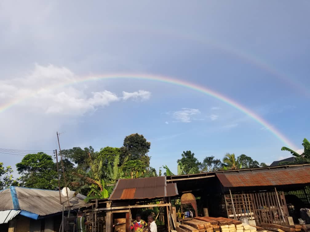 Rainbow across the blue sky with clouds