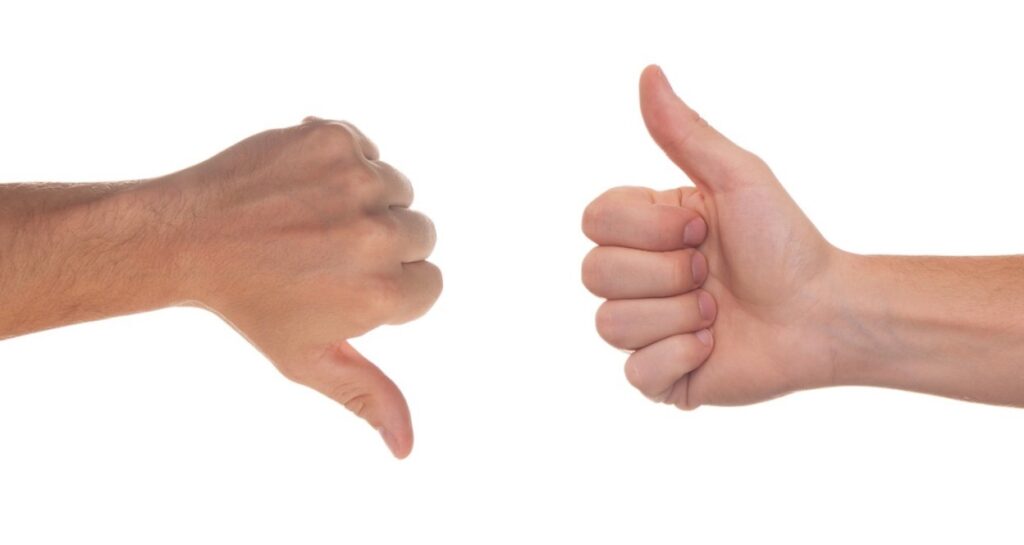 Two hands shown against a white background, with the left hand giving a thumbs-down gesture and the right hand giving a thumbs-up gesture.Â