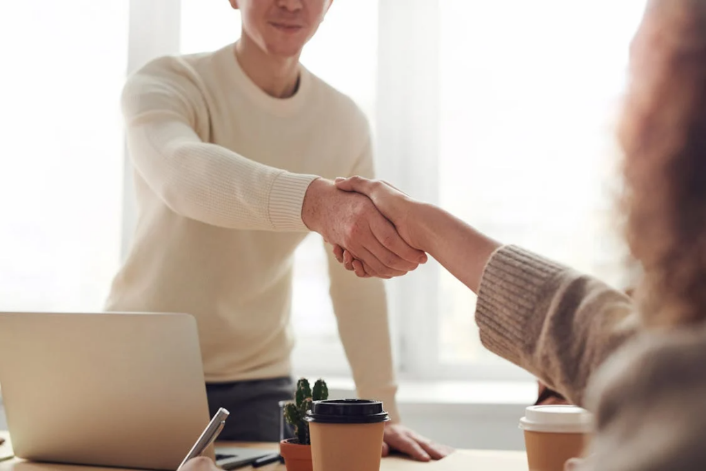Two professionals in business attire shaking hands in close-up.