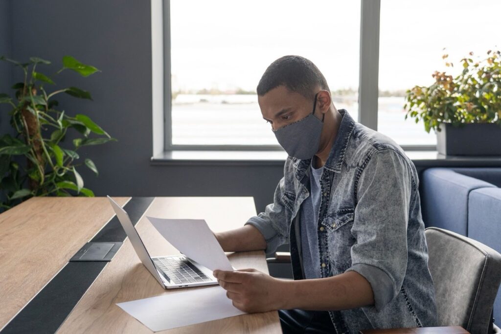 Business owner reviewing trust documents at a desk with legal paperwork and a laptop