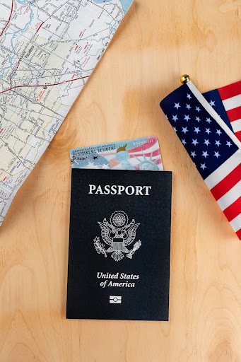 U.S. passport and American flag on a desk.