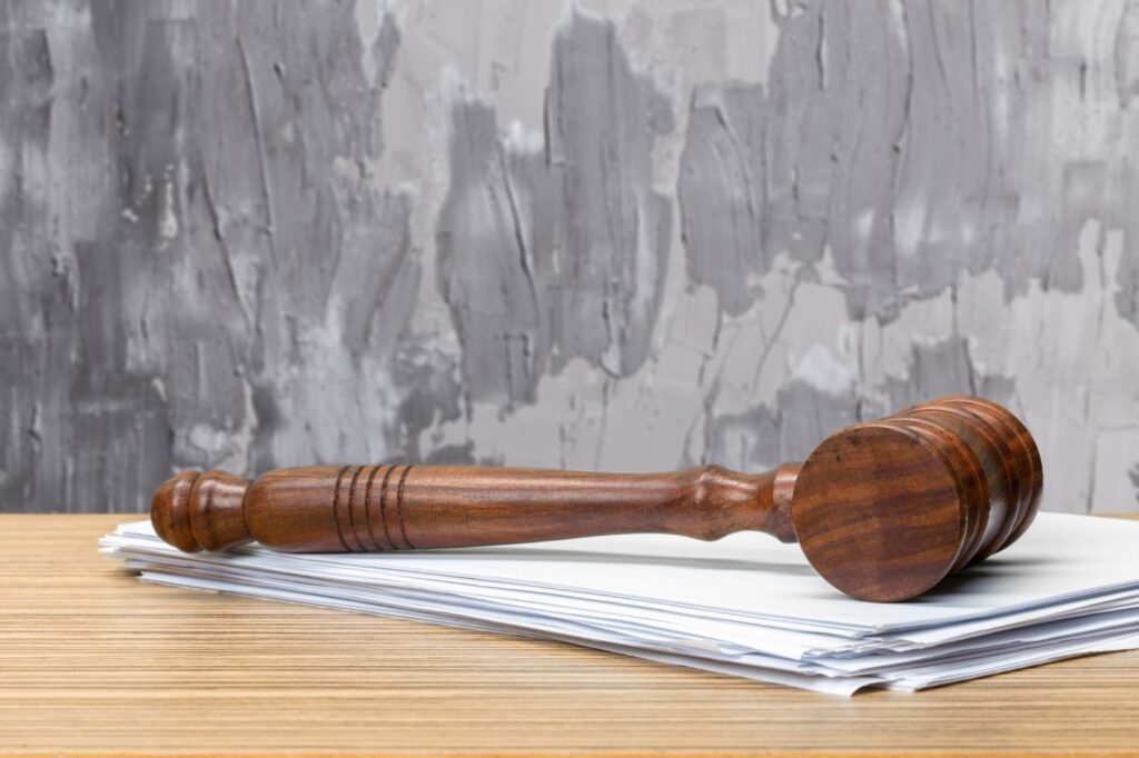A judge's gavel resting on legal documents on a desk.