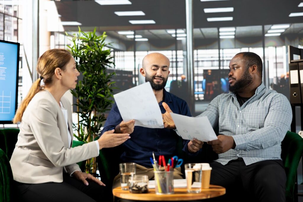 A group of people signing a private membership agreement around a table.