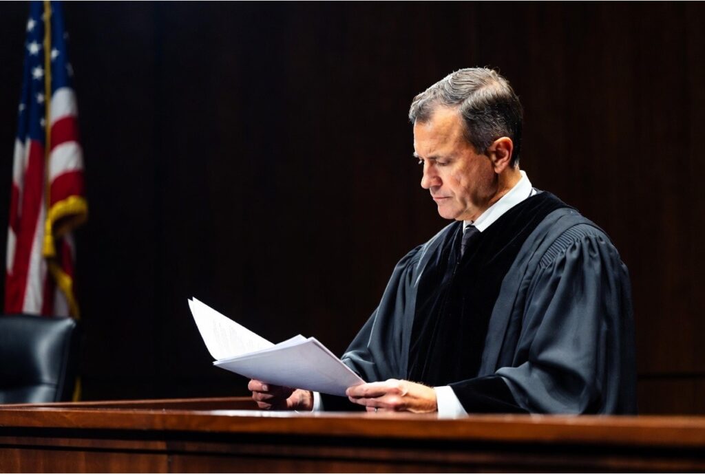A judge examining legal documents in a courtroom