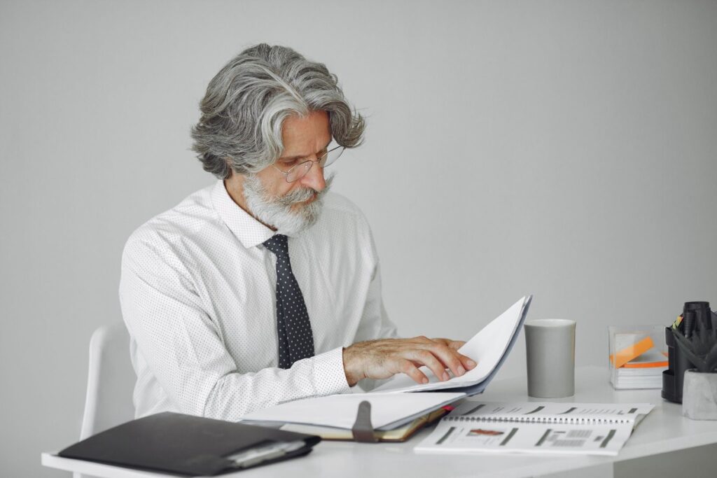 A nonprofit administrator reviewing IRS classification documents, comparing private foundation and public charity requirements at a desk.