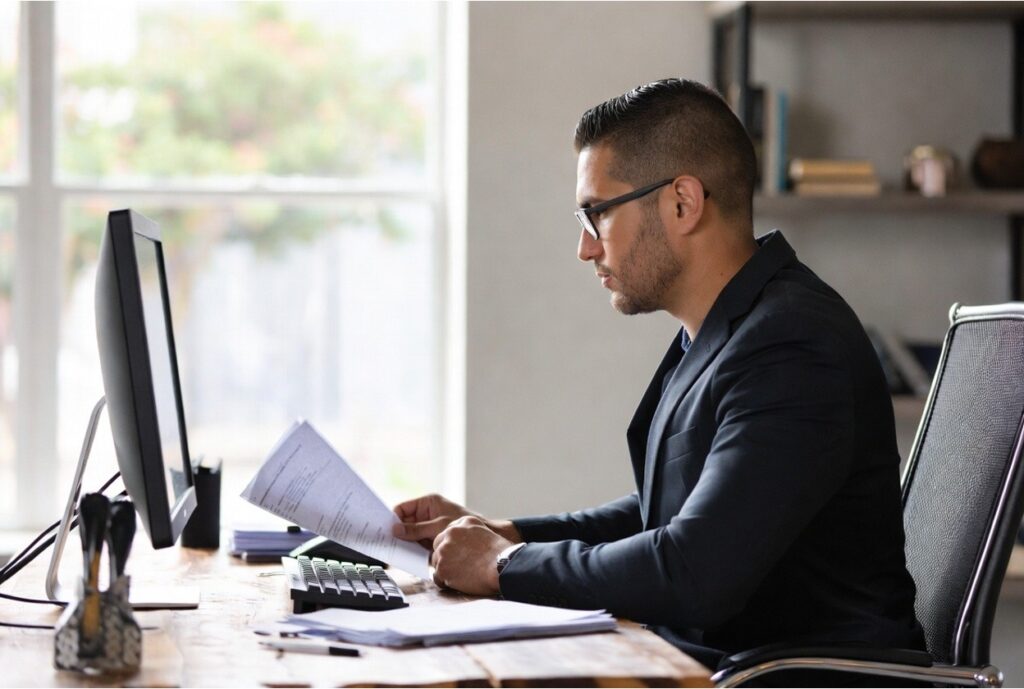 Church administrator reviewing 508(c)(1)(a) tax exemption and EIN requirements documents at a desk