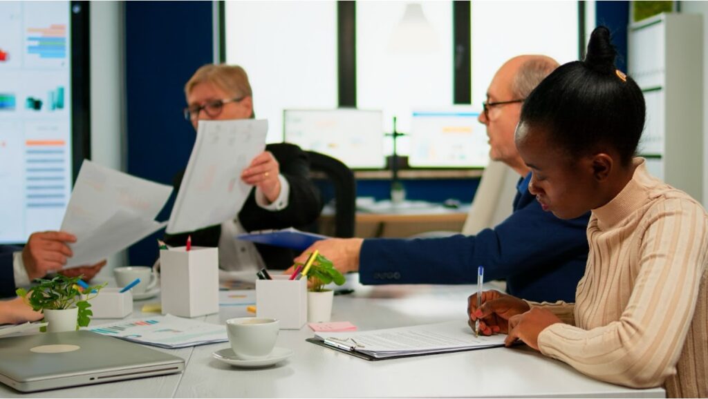 Nonprofit board members reviewing tax-exempt filing paperwork at a conference table