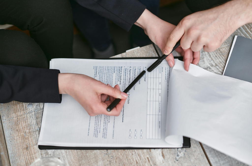 Two people reviewing paperwork on a wooden table