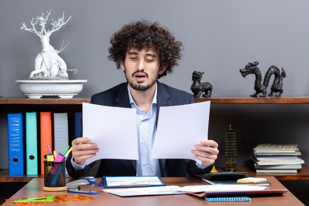 A tax professional analyzing private foundation and public charity tax obligation documents on a desk.
