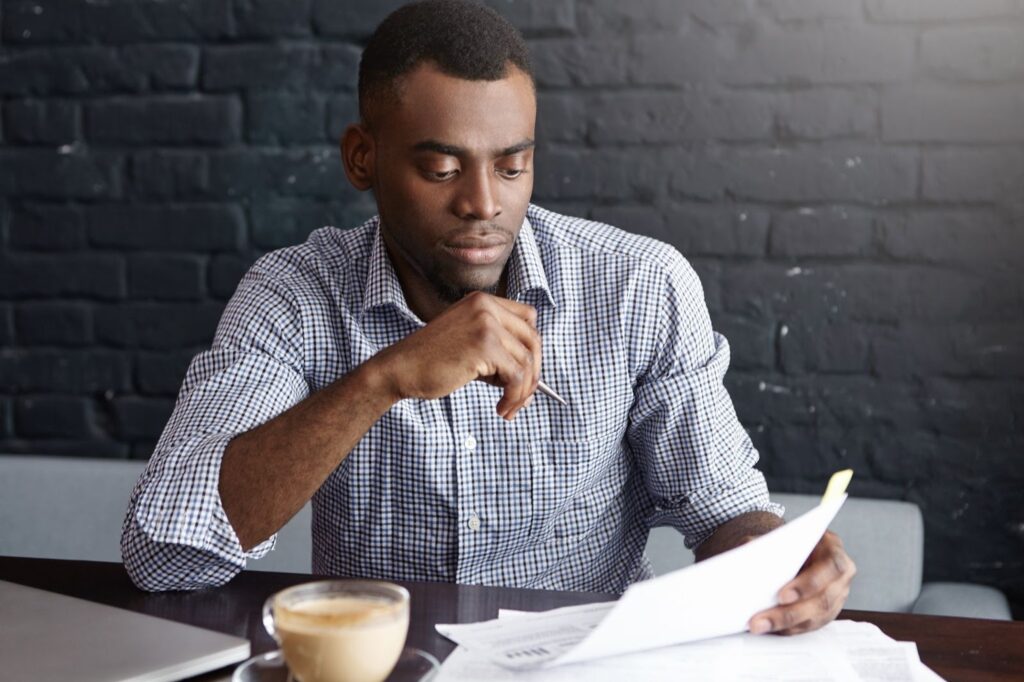 A person filling out IRS tax exemption application forms at a desk.