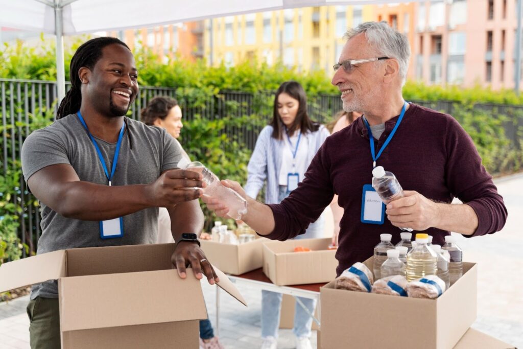 Volunteers packing water and food donations at an outdoor community distribution event
