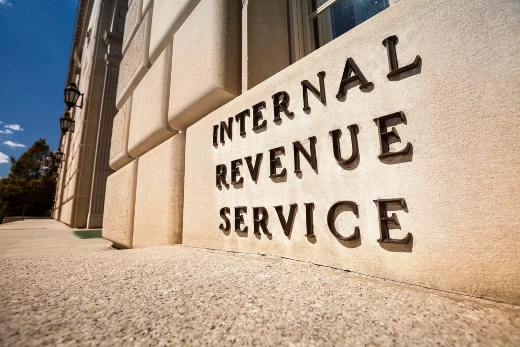 Low-angle view of the Internal Revenue Service building with engraved lettering on its stone facade.