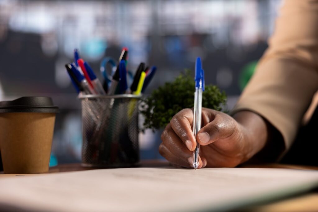 Person signing an express trust deed document at a desk.