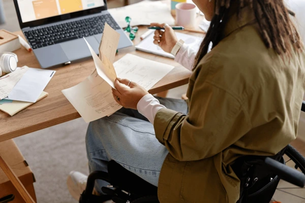 Business owner reviewing PMA setup paperwork and calculating Private Membership Association formation costs at her desk