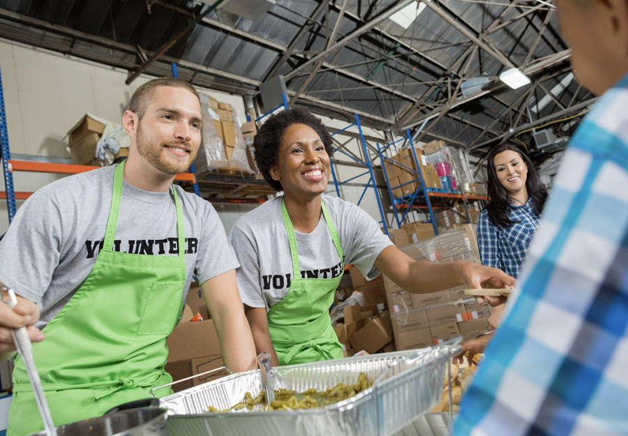 Community volunteers serving meals at a 501(c)(3) public charity soup kitchen, illustrating the public-facing nature of broad-benefit non-profit work