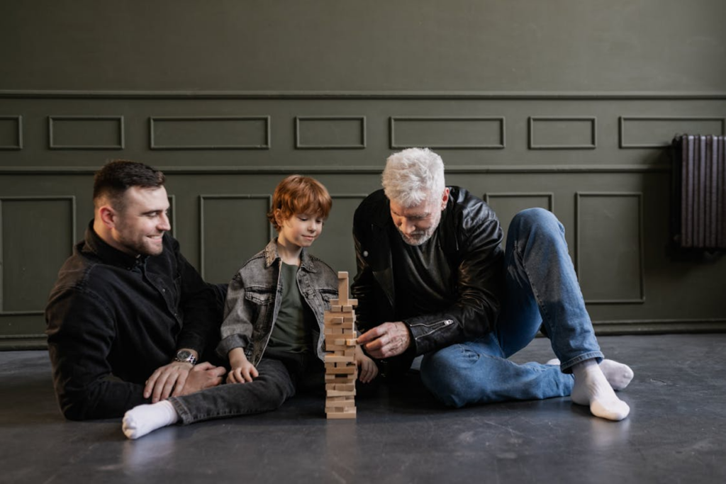 Multiple generations playing together with Jenga on the floor, showing family unity and support