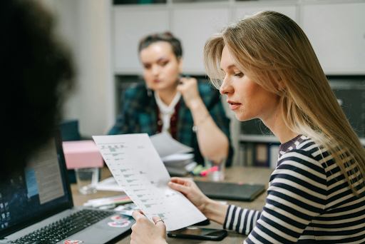 Woman in a striped shirt reviewing LLC alternative documents during an office meeting