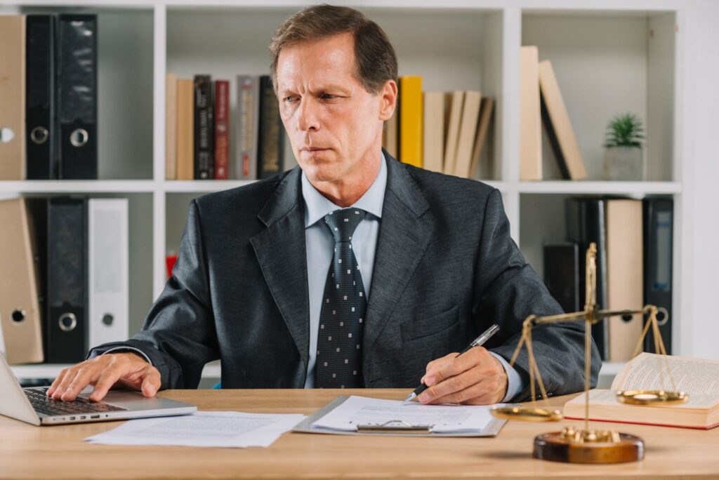 Lawyer reviewing legal compliance documents at a desk.
