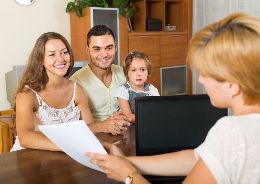Parents and their daughter meeting with a financial advisor to review family limited partnership documents.