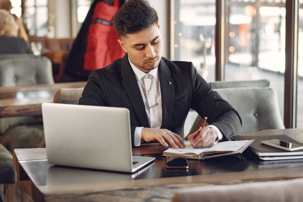 A small business owner reviewing LLC formation documents at a desk with a laptop.