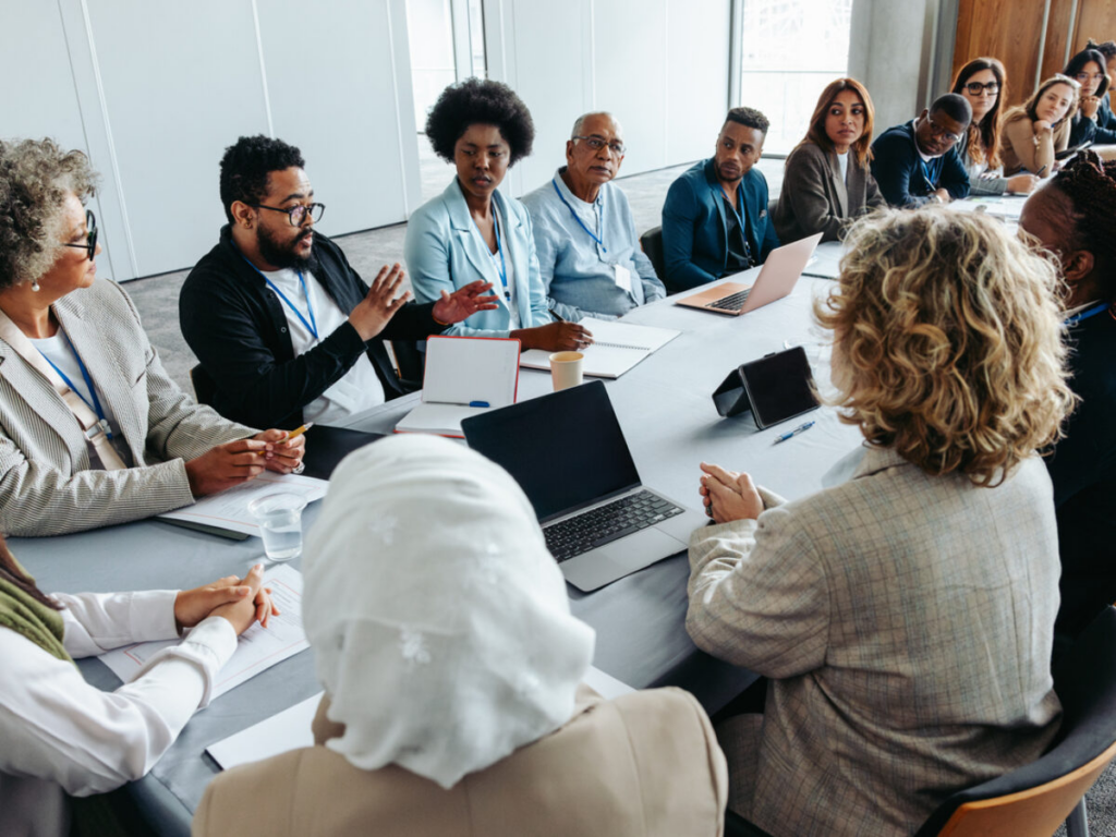 Diverse nonprofit founders and board members reviewing entity classification options around a conference table with laptops and notepads.