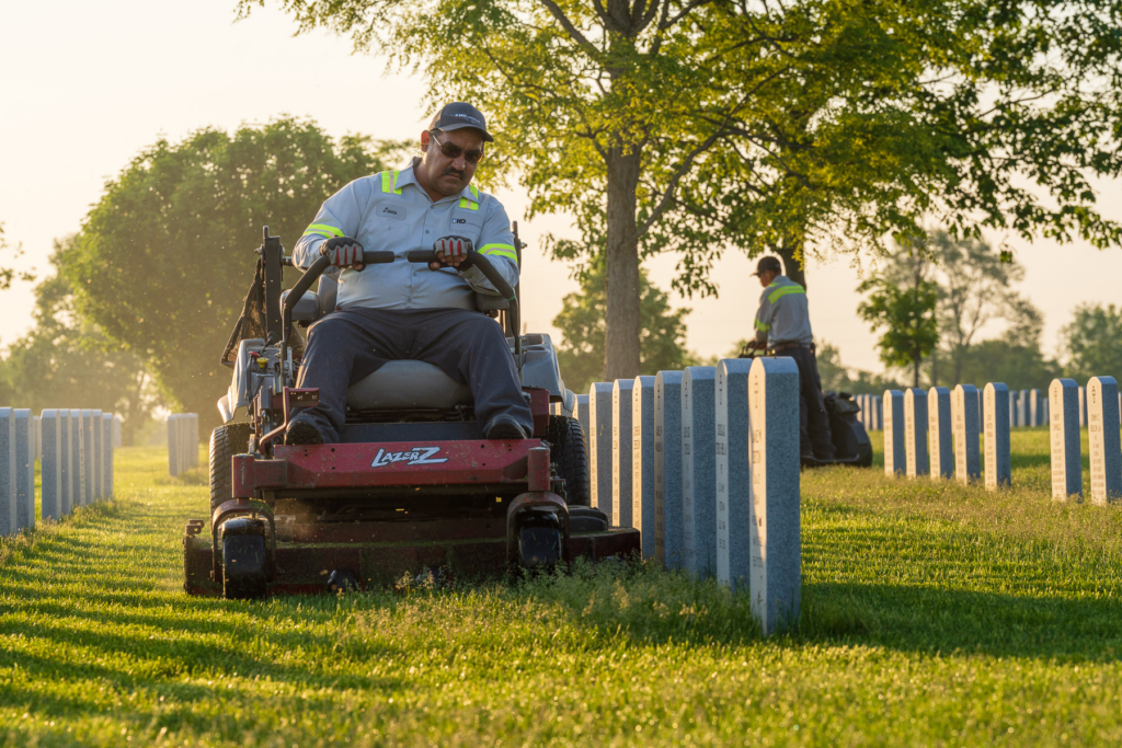 Cemetery groundskeeper maintaining headstones and lawns at a 501(c)(13) nonprofit cemetery, illustrating the long-term stewardship funded by perpetual care reserves.