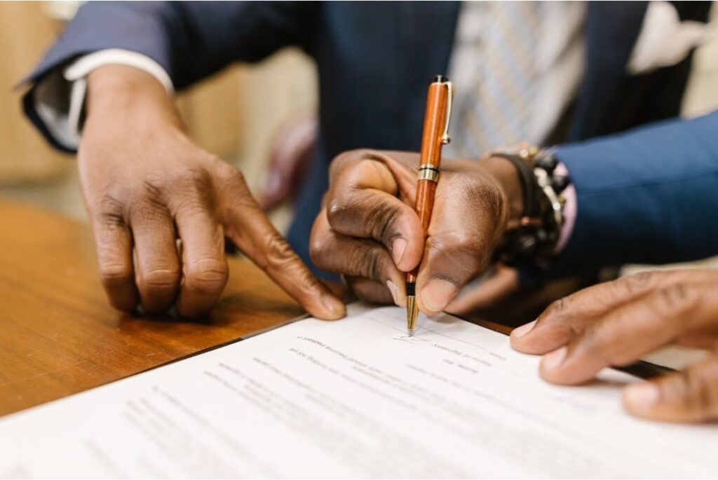 Close-up of a person signing a trust document.