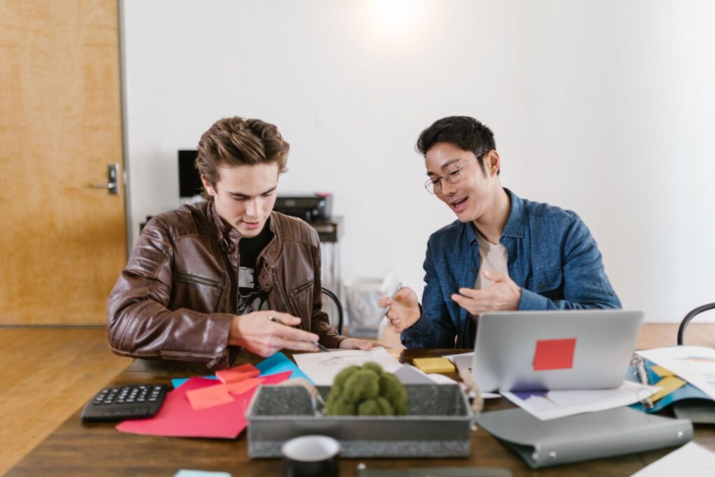 Two young professionals reviewing design sketches and notes.