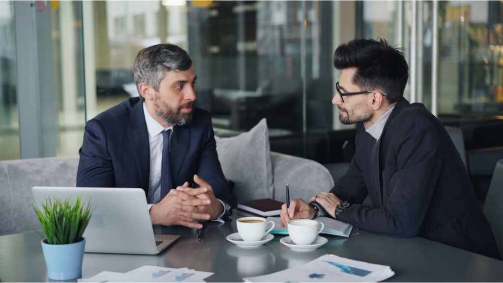 Two professionals discuss nonprofit tax classification documents during a business consultation
