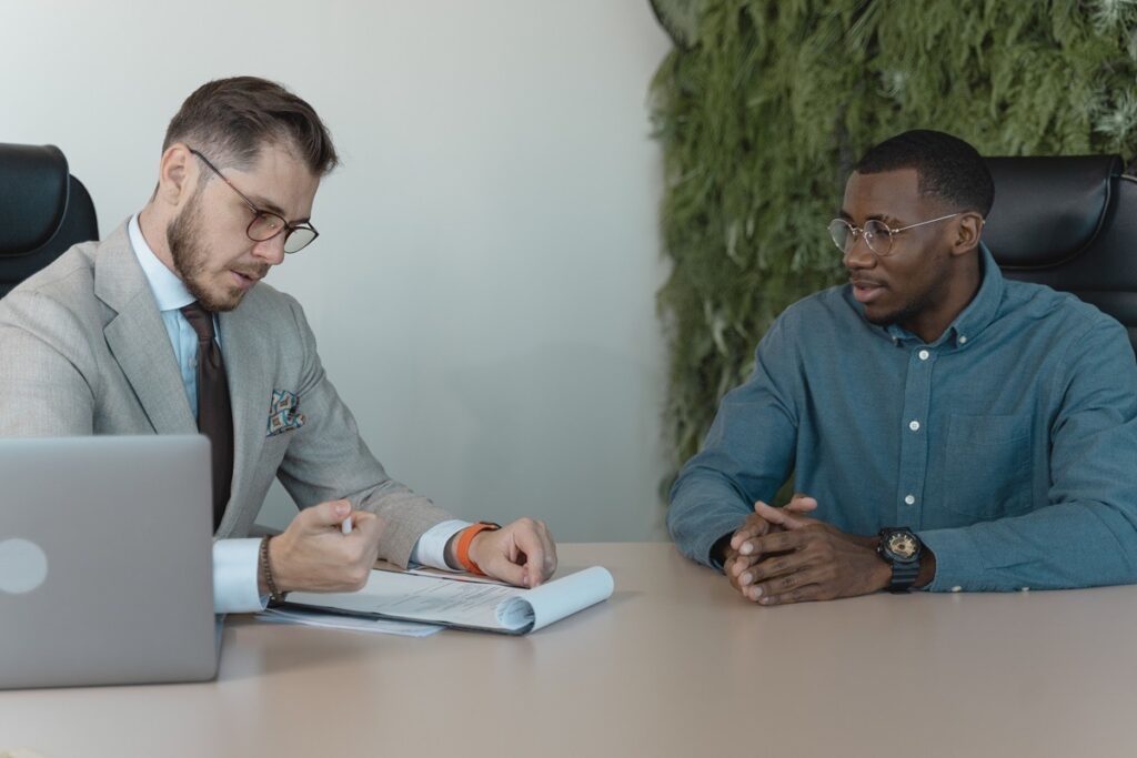 Two professionals review private membership association documents during a legal consultation