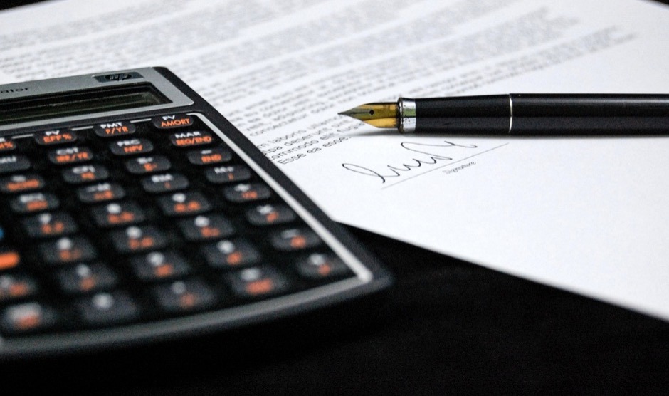 A calculator and a piece of paper, signifying how the costs of setting up a Cook Islands asset protection trust add up.
